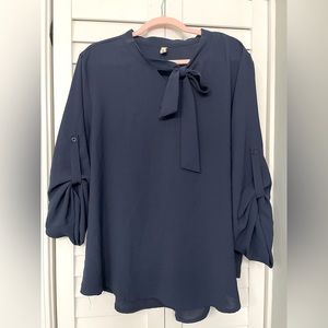 Navy blue blouse with bow neckline and 3/4 sleeves.